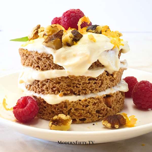 Low-carb carrot mug cake on a plate. Toped with raspberries and basil leaves.